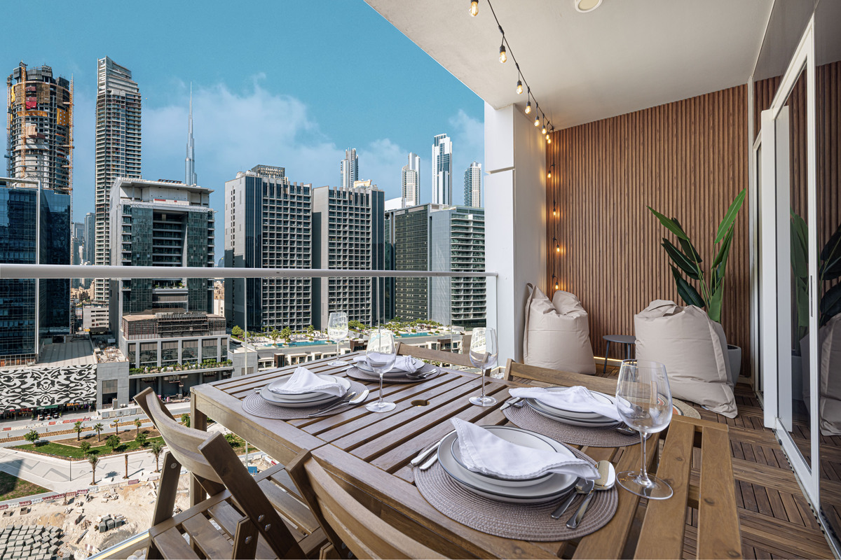 Balcony dining area with Burj Khalifa and Business Bay skyline at sunset